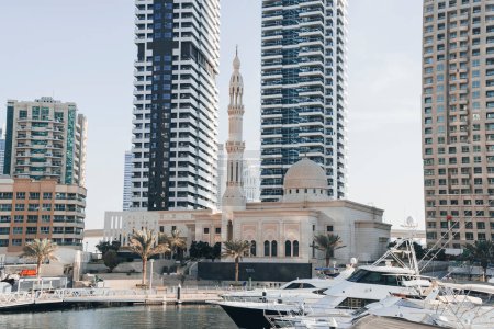 Foto de Imponiendo la gran mezquita Mohammed Bin Ahmed Al Mulla entre los edificios de gran altura de la Marina de Dubai en el puente de Al Emreef Street. - Imagen libre de derechos