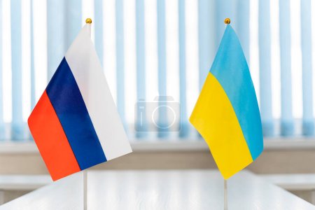 Photo for Close up Russian and Ukrainian flags. Diplomats negotiate on war between Russia and Ukraine. International relations. Conflict settlement and negotiations. Diplomacy. - Royalty Free Image