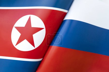 Hintergrund der Flaggen Nordkoreas und Russlands. Konzept der Interaktion oder Gegenwirkung zwischen den beiden Ländern. Internationale Beziehungen. politische Verhandlungen. Sportwettbewerb.