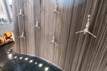 Foto de Dubai, Emiratos Árabes Unidos. 28 de noviembre de 2022: Famosa cascada en Dubai Mall, Hombres voladores. El centro comercial más grande del mundo - Imagen libre de derechos