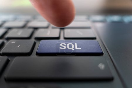 Sql text created with keyboard keys, computer terminology, sql on black keyboard