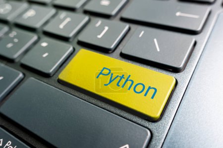 button with the python on the yellow keyboard of a modern laptop.-stock-photo