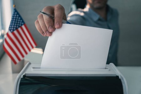 Election or referendum in United States. Voter holds envelope in hand above ballot. USA flag