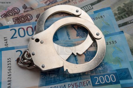 Photo for Metal handcuffs against the background of the cash currency russian ruble. The concept of bribery or criminal money. - Royalty Free Image
