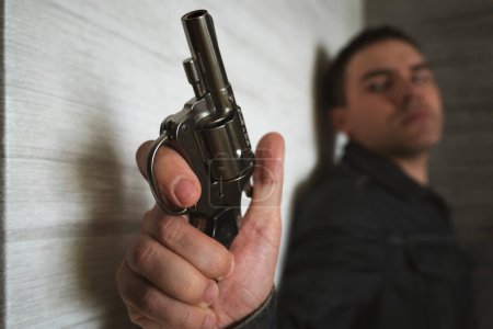 Photo for Threat to life. Close-up of hand with pistol. Shootout of criminals with revolvers. Killer or murderer. bandit hides in the dark with a firearm. the shooter is in ambush - Royalty Free Image