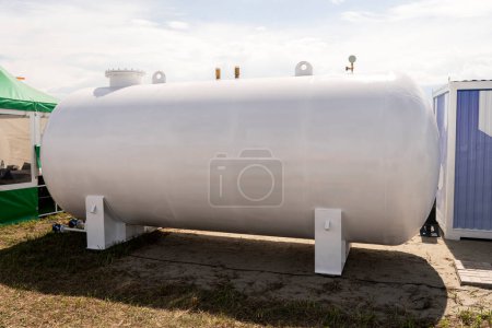 large white liquid storage tank outside. a barrel for fuel or water