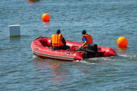 Téléchargez les photos : Sauveteurs sur un bateau gonflable rouge patrouille la mer. - en image libre de droit