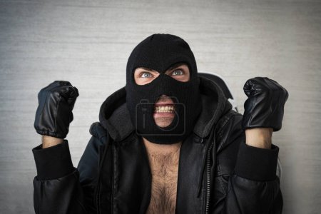 Téléchargez les photos : Un voyou masqué agressif en colère crie de colère. - en image libre de droit