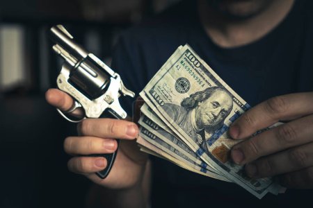 Photo for The concept robbery. the robber keeps a gun and cash in the river - Royalty Free Image