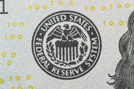 Foto de Primer plano del logo del Sistema de Reserva Federal. El emblema de la Reserva Federal de EE.UU. en billetes de cien dólares mientras la FED considera la subida de las tasas de interés, la economía y la organización nacional de control de la inflación. - Imagen libre de derechos