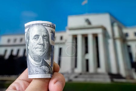 a hundred-dollar bill on the background central bank. Federal Reserve Building in Washington DC, United States