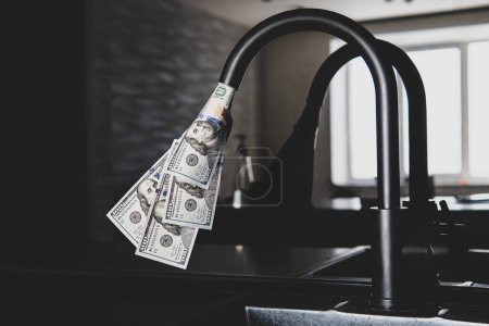 Tap with dollars flowing out of it. Expensive water supply. The concept of increasing the price of public utilities for the population. Expensive hot and cold water at home.
