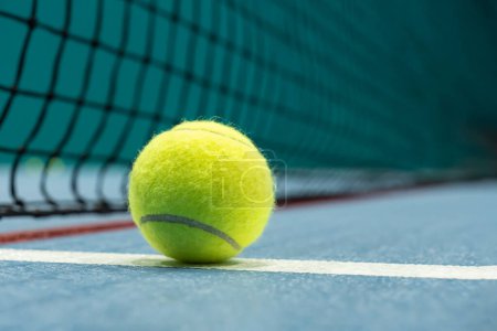 Piłka tenisowa na niebieskim korcie. koncepcja sportowego stylu życia.
