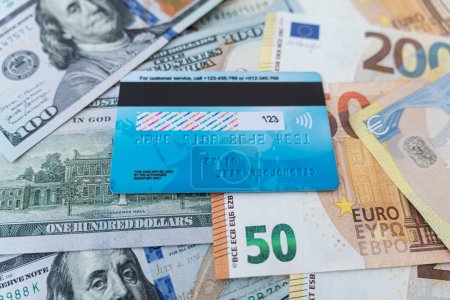 Photo for Top view of credit card on money in various currencies. Dollars, euros. The global economic crisis. Financial literacy. Currency basket. multi-currency card of payment system. exchange stock exchange - Royalty Free Image