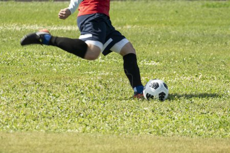 Foto de Jugador de fútbol masculino golpea la pelota en el campo - Imagen libre de derechos