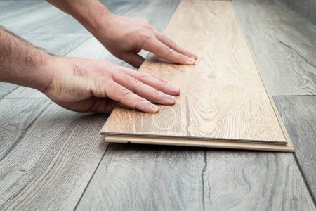 Photo for Close up of laminated flooring during replacing process. replacement of damaged laminate flooring. Renovation in the apartment. Choice of parquet - Royalty Free Image
