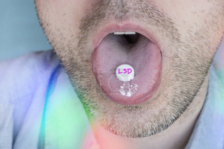 The guy swallows a pill with narcotic acid in close-up. Dependence on synthetic drugs. mug #674535138