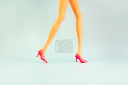 Photo for Doll legs on blue background, copy space. - Royalty Free Image