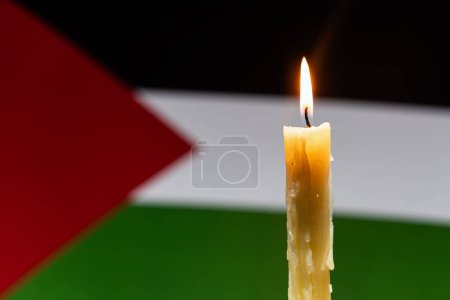 Téléchargez les photos : Le deuil dans la campagne palestine, bande de gaza. Une bougie allumée sur le fond du drapeau palestinien. Victimes du cataclysme ou concept de guerre. Le deuil national. guerre au Moyen-Orient - en image libre de droit