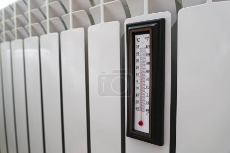 Téléchargez les photos : Thermomètre de radiateur de chauffage réglé à basse température et thermomètre ambiant pour économiser de l'argent aux coûts de chauffage. Crise énergétique, efficacité énergétique et augmentation des coûts de chauffage en Europe. 17 degrés Celsius. - en image libre de droit