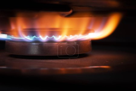 Foto de Quemador de gas en estufa de cocina moderna negra. cocina cocina de gas con fuego ardiente gas propano. consumo de gas natural - Imagen libre de derechos