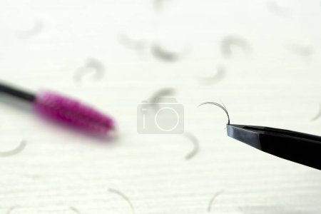 Photo for Eyebrow paint brushes, tweezers, on a beige background. The concept of beauty, eyebrows. Plucking eyebrows. Small hair eyebrow brush and tweezers on a white table. The concept of self-care. - Royalty Free Image