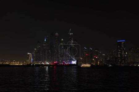 Foto de Panorama nocturno de Dubai Marina. Hermosa vista nocturna de los rascacielos de Dubai desde el mar. - Imagen libre de derechos