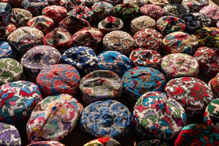 Photo for A lot of colorful beautiful skullcaps on a table at a street bazaar in the old city of Khiva, Khorezm region, Uzbekistan. - Royalty Free Image
