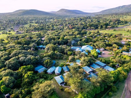 Blick von oben auf ein Zeltlager in der afrikanischen Savanne. Zelte im Wald in Afrika. Luftbild.