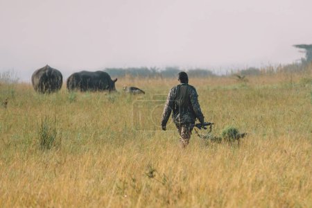 Foto de Un soldado africano en uniforme militar patrulla el territorio del Parque Nacional Nairobi en Kenia. - Imagen libre de derechos