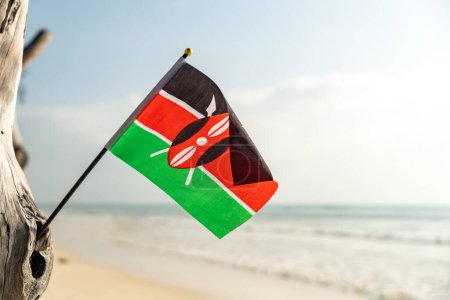 Téléchargez les photos : Le drapeau du Kenya sur une belle plage de sable blanc propre. Le concept de loisirs en République kenyane. - en image libre de droit
