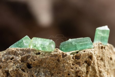 Foto de Conjunto de cristales de turmalina en el fondo de piedra áspera en luz natural - Imagen libre de derechos
