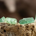 Set of Tourmaline Crystals on Rough Stone Background in Natural Light
