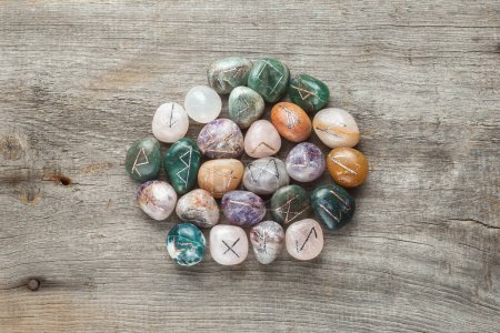Téléchargez les photos : Elder Futhark Rune Stones Set Made of Natural Gemstones on Wooden Background - en image libre de droit
