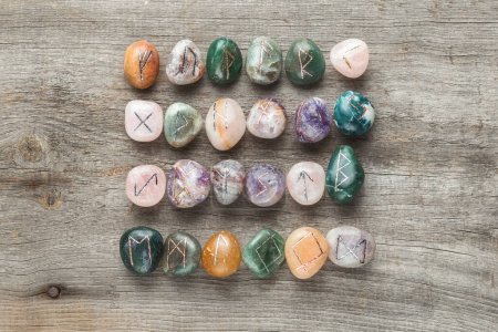 Photo for Elder Futhark Rune Stones Set Made of Natural Gemstones on Wooden Background - Royalty Free Image