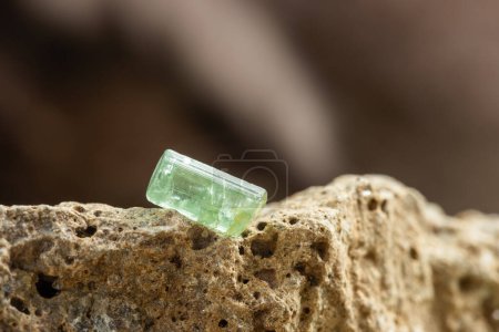 Photo for Raw Green Tourmaline Crystal on Rough Stone Background in Natural Light - Royalty Free Image