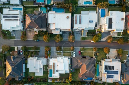 Am späten Nachmittag von oben nach unten Luftaufnahme moderner gehobener Häuser mit Pools und Solardächern in einem Vorort von Sydney, Australien