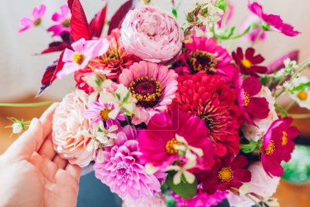Top view of bouquet of pink rose dahlia zinnia flowers. Interior and summer decor at home. Woman enjoys fresh blooms. Close up of floral arrangement