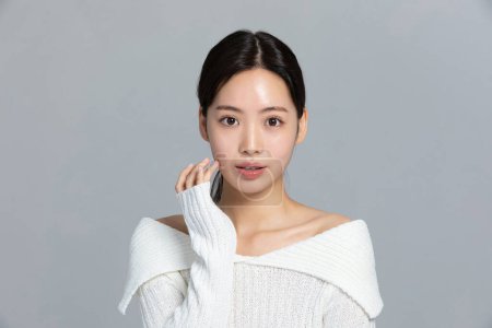 schöne junge koreanische asiatische Frau Porträt Studio Foto im Winter Haut Schönheit und Kosmetik-Konzept, lächelnd mit Handbewegung