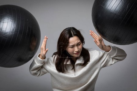 gestresste, depressive koreanische Geschäftsfrau im rosa Anzug, erschöpft