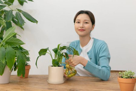 glückliches Single-Leben einer Koreanerin, die zu Hause Pflanzen anbaut