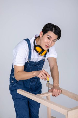 millennials and gen z, korean asian young man carpenter assembling furniture