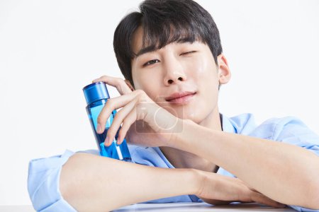 koreanisch asiatisch jung mann mit hautpflege produkt