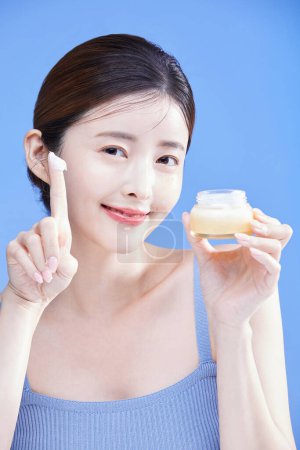 beauty concept photo of korean asain beautiful woman with a creem, cosmetics, studio background
