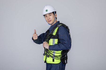millennials and gen z, korean asian young man, site staff standing with a power cable and hand motion, studio background