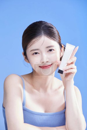 beauty concept photo of korean asain beautiful woman holding a cream, studio background