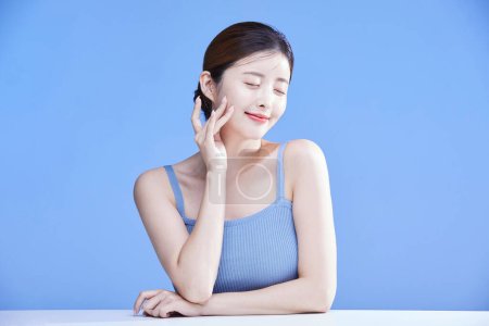 beauty concept photo of korean asain beautiful woman touching her face with her eyes closed, studio background