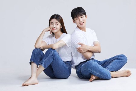 korean asian young couple standing back to back, studio background