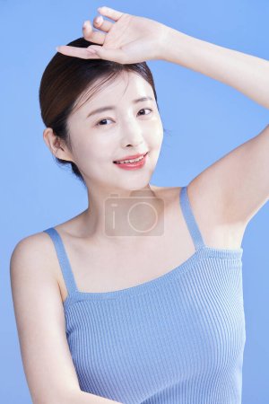 beauty concept photo of korean asain beautiful woman smiling while shielding herself from the sunlight, studio background