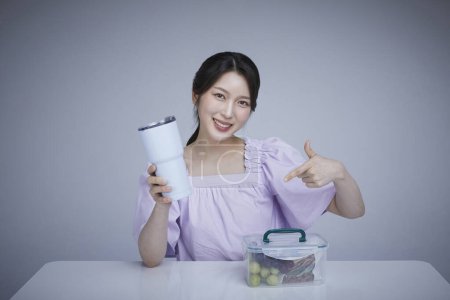 Koreanisch asain schöne Frau mit einem Becher und Plastikeimer Finger in Bewegung.